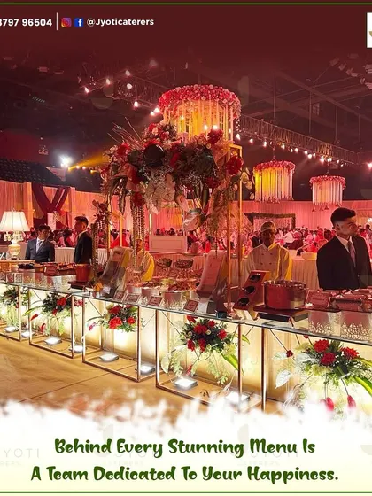 A wide view of a grand wedding hall where our team has set up an extensive buffet line, complete with elegant floral arrangements and dedicated staff for each section.