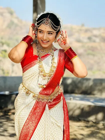 An actress styled in a traditional Kerala bridal look, featuring layered gold necklaces and a statement headpiece (matha patti) from my collection.