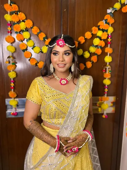 The full mehendi look, with Simran looking radiant against a backdrop of marigolds. The makeup is perfectly suited for the festive occasion.