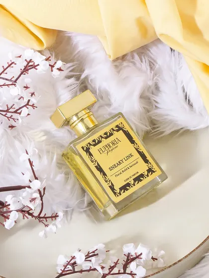A soft and delicate composition for 'Sneaky Link' perfume. The fluffy white texture and yellow fabric create a light, airy, and sensual mood.