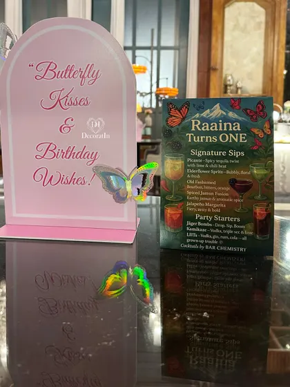 "Butterfly Kisses & Birthday Wishes." This custom sign, complete with a holographic butterfly, adds a personal and thematic touch to the table decor.