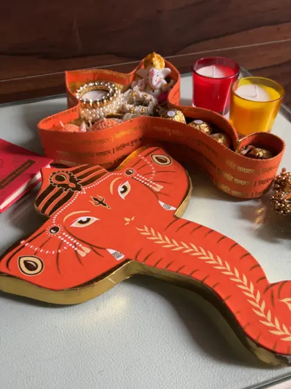 The Ganesha-shaped box displayed with scented candles, ready to be gifted.