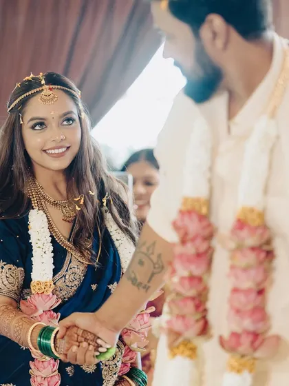A sweet moment during the wedding ceremony. The bride's radiant smile and sparkling eyes are the focus, enhanced by a makeup look that is both traditional and fresh.