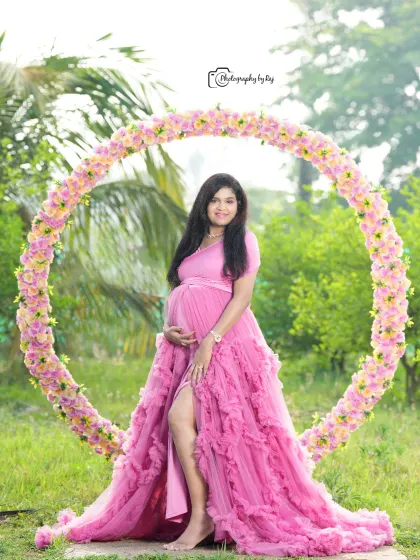 A lovely portrait using our circular floral prop. The mother-to-be looks radiant in a pink ruffled gown, creating a beautiful composition.