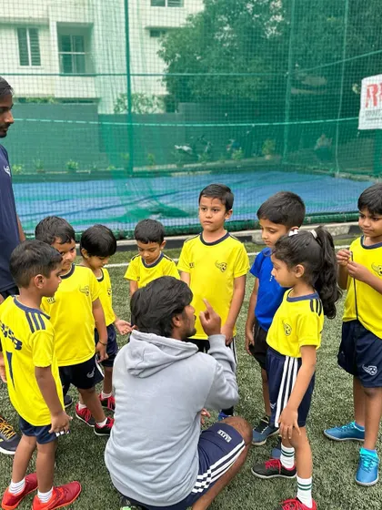 A coach explains a drill to a group of attentive young players. We ensure everyone understands the task before we begin.