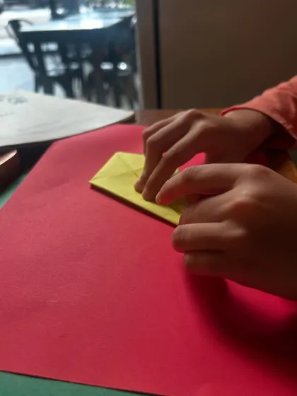 The simple act of folding paper can teach complex concepts. These small hands are busy creating patterns and shapes, learning about symmetry and angles without even realizing it. This is the magic of multi-sensory learning.
