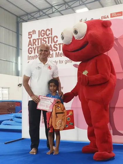 Presenting an award to a young participant at the IGCI meet. We encourage gymnasts of all levels to participate and gain experience.