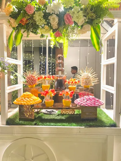 A chocolate fountain as the centerpiece of the fruit cart display.