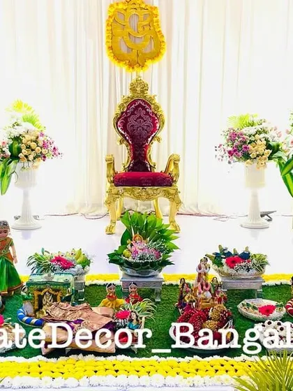 A beautiful and traditional seemantham setup with a royal chair and floral arrangements. My decorated platters are placed in the foreground, completing the ceremonial space.