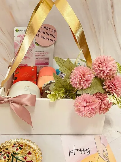 A close-up of the white basket hamper for a sister, showing the arrangement of flowers and gifts.