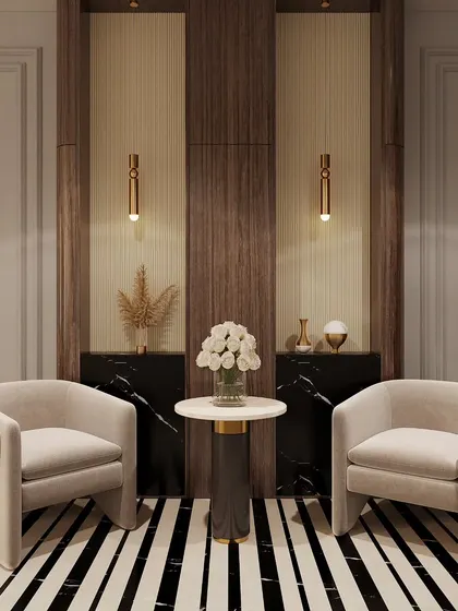 We create elegant seating nooks perfect for quiet moments. This corner features two plush armchairs, a marble side table, and a backdrop of wood and black marble paneling with delicate pendant lights for focused illumination.