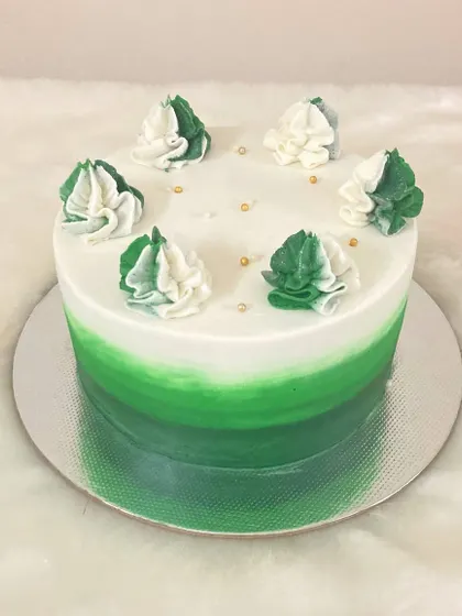 A simple yet beautiful green ombré cake. The gradient color effect is created with buttercream, and the two-toned piped swirls on top add a final artistic touch.