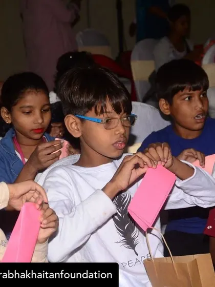 A young boy concentrates on making his own puppet during a community workshop. The hands-on process of creating is just as important as the performance itself.