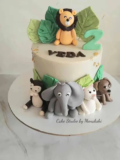 A sweet jungle themed cake for Veda's second birthday. I placed the handcrafted lion on top and arranged the other friendly animals like the elephant and monkey around the base.