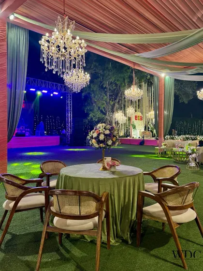 The guest seating at the 'Floral Serene Grandeur' reception. Tables were dressed in soft green velvet, set under a canopy of pastel drapes and crystal chandeliers.