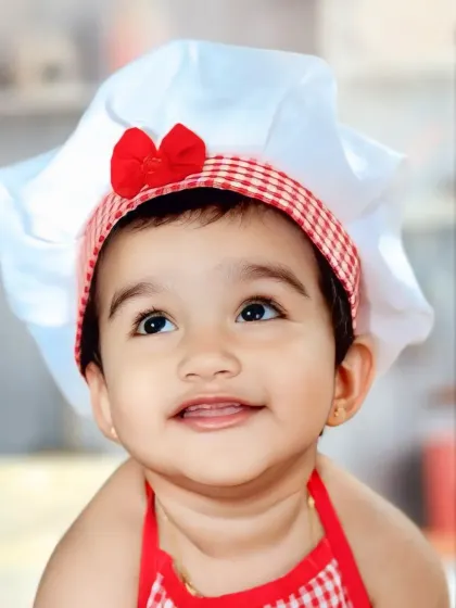 This close-up from our 'Little Chef' theme captures the pure delight and curiosity of a child. We focus on bright eyes and happy smiles to create portraits that are full of life and personality.