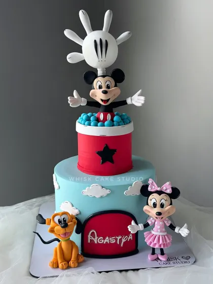 A fun Disney-themed cake featuring Mickey, Minnie, and Pluto. This design includes a pop-up Mickey, creating a playful and interactive centerpiece.