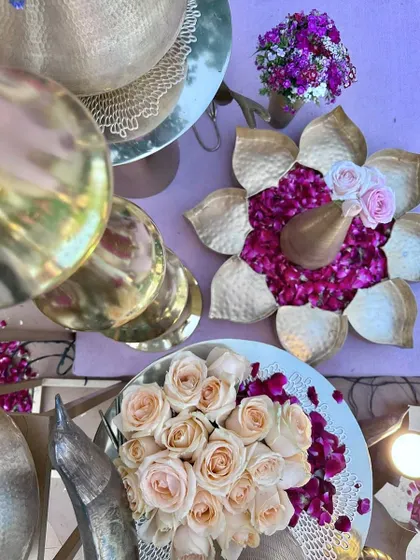 A close-up of the decor details for the vedi, including brass urlis filled with fresh roses and petals.
