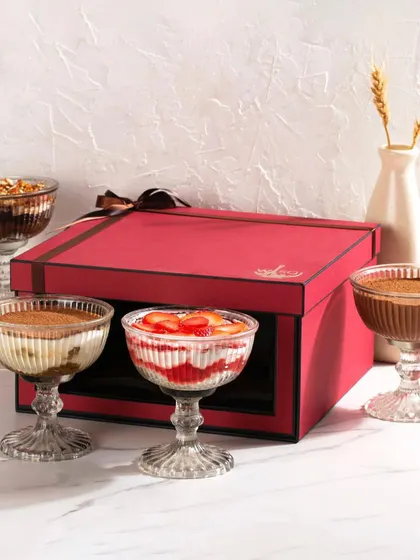 'Tis the season to be jolly. For Christmas, we offer these festive red gift boxes filled with a selection of four different dessert cups, including our Strawberry & Cream Cheese Trifle, perfect for sharing with loved ones.