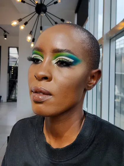 Another view of the creative green and blue eye makeup, showing the blend of colors and the sharp wing.