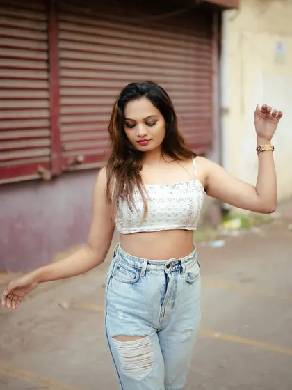 A candid-style street portrait. The model's natural movement and the gritty urban background create an authentic and relatable fashion shot.