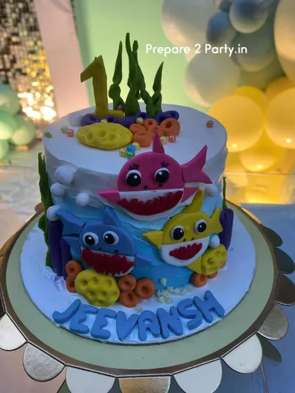 A close-up of a custom Baby Shark themed cake. I can coordinate with your baker to ensure every element of the party, including the cake, matches the decoration perfectly.