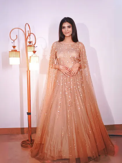 A classic pose in the golden gown, perfect for any formal event.