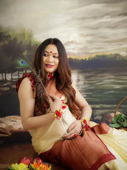 A traditional portrait with a touch of divinity. The mom-to-be is dressed in a classic saree, holding a peacock feather, evoking a sense of grace and heritage.