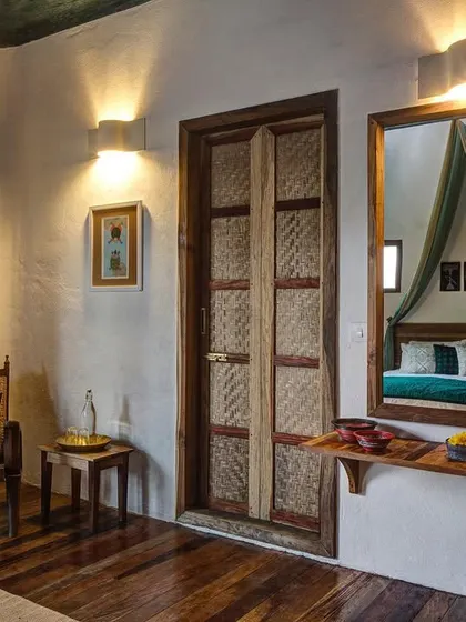 The interior of the Tower Room, where a mirror reflects the canopied bed, creating a sense of depth and romance.