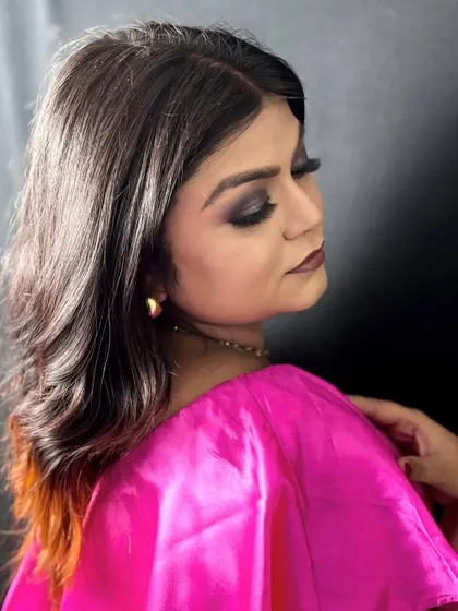 A side profile of the smokey eye look, highlighting the blending of the eyeshadow and the soft waves in the hair.