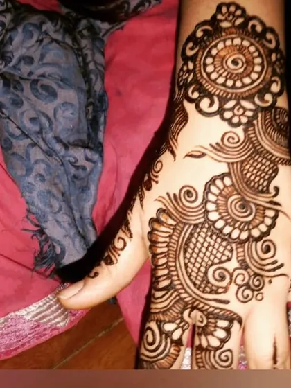 A simple yet elegant Arabic-style design focusing on the back of the hand, with swirls and a central mandala.