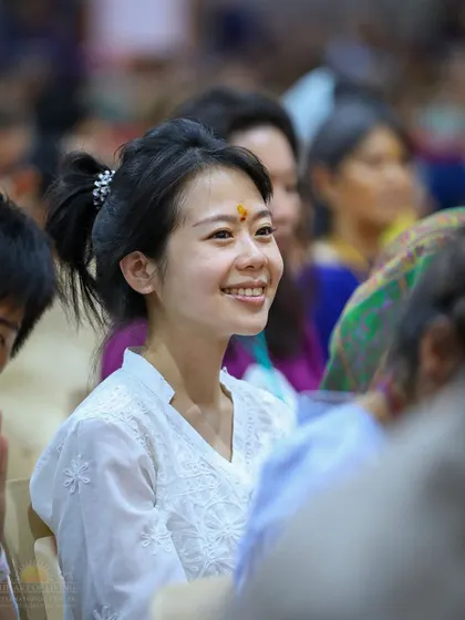 A young woman from our international community smiles, her face radiant with joy during a homa. The experience of these sacred ceremonies often leaves people feeling light and blissful.