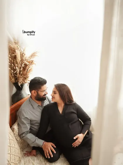 A simple and cozy indoor maternity session. This photo captures a quiet, intimate moment between the expecting couple in a relaxed, natural setting.
