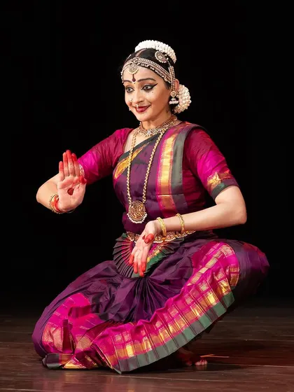 A seated pose expressing the anticipation and hope of the Nayika. The subtle smile and focused gaze are part of the intricate abhinaya used to tell her story.