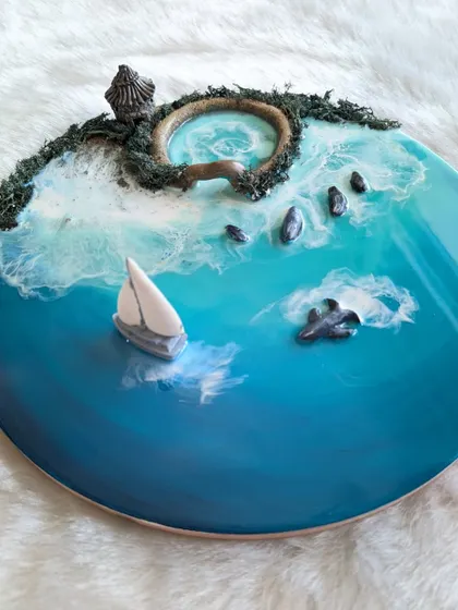 Bring the calm of the sea into your home with a custom resin ocean artwork. This piece features a miniature seascape complete with a tiny boat, gentle waves, and a mossy shore, all captured in glossy, touchable resin.