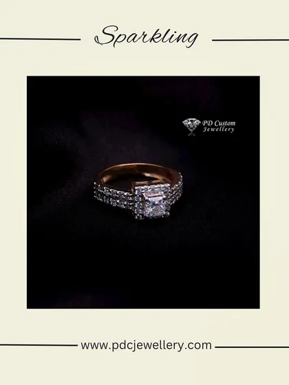 A sparkling princess-cut diamond engagement ring. The center stone is set on a band that is also encrusted with diamonds, creating a look of continuous brilliance.