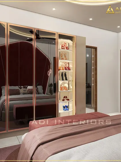 A glimpse into a glamorous bedroom, with a reflection in the mirrored wardrobe showing a plush red headboard. The wardrobe itself features a beautifully lit, open-shelf section for displaying shoes.
