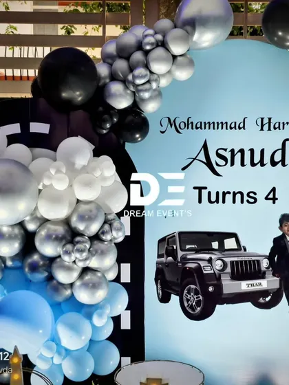 A personalized backdrop for the Thar-themed party, featuring a photo of the birthday boy with his favorite car.