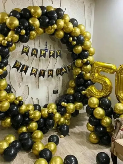 A bold black and gold balloon ring for a 50th birthday. This decoration makes a strong statement and is perfect for celebrating a half-century milestone.