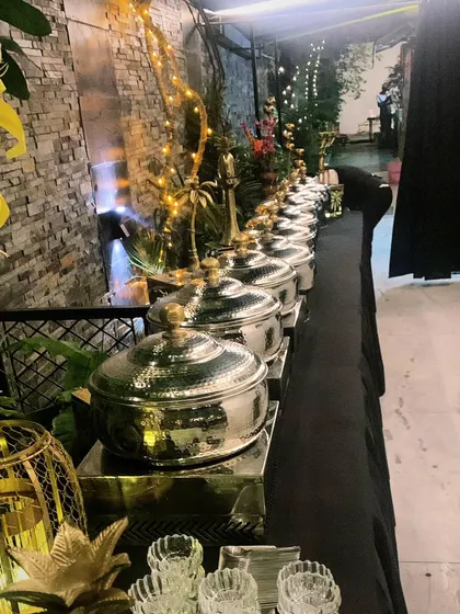 A beautifully lit evening buffet for 70 guests in Maharani Bagh, showcasing our hammered-finish chafing dishes.