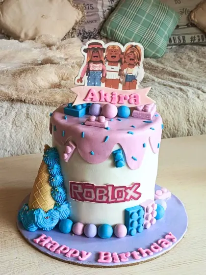 A fun and trendy Roblox-themed cake with a pink drip effect, game-inspired blocks, and a custom character topper for a stylish gamer's birthday.