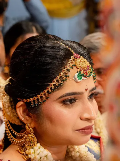 A close-up of this bride's traditional look, focusing on the intricate matha patti and her defined eyes.