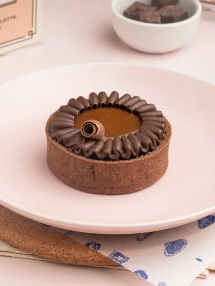 The rich, dark filling of my Sea Salt Caramel Tart, surrounded by a piped border of chocolate cream.