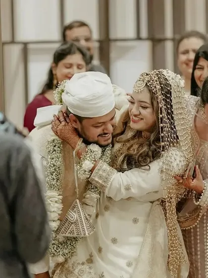 A heartwarming hug between the couple after their Nikah ceremony, surrounded by smiling family and friends.