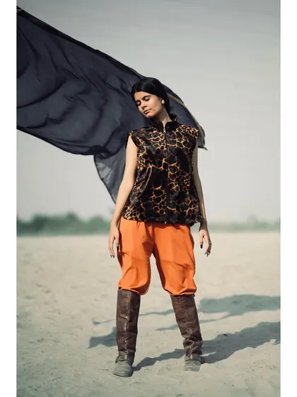 Another shot from the same outdoor series, this time with the model holding a flowing black fabric. The movement in the fabric adds a dynamic and ethereal quality to the fashion photograph.