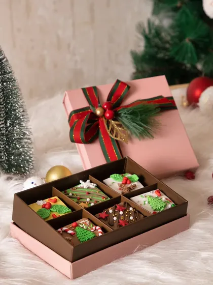 A box of our handcrafted Christmas brownies, each one decorated with festive designs. These are perfect for corporate gifting or sharing at holiday parties.