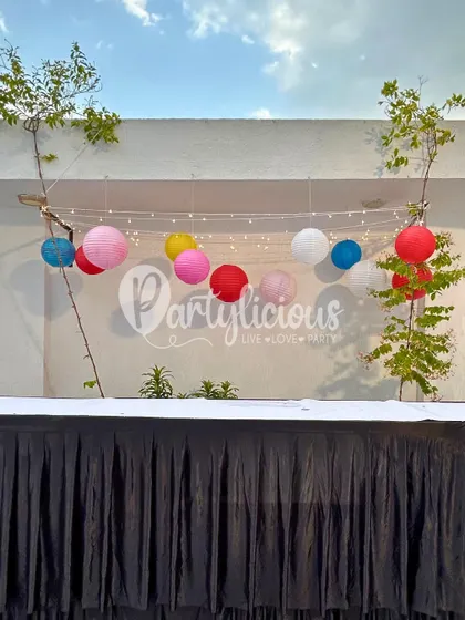 Simple yet effective outdoor party decor. I used colorful paper lanterns and fairy lights to create a festive and cheerful ambiance for a casual get-together on a terrace.