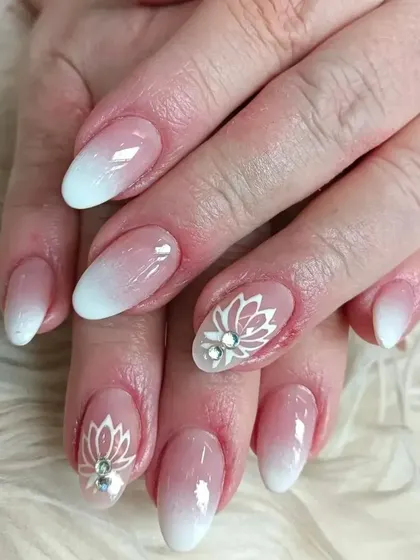 We combined a soft ombre base with delicate, hand-painted white lotus art and a single rhinestone for an elegant, custom design.