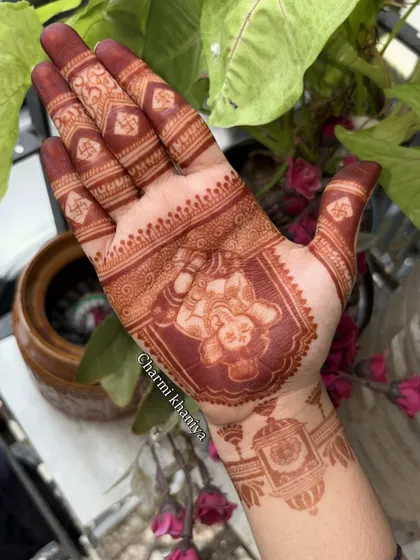 A close up of the beautiful, rich stain from a Ganpati mehendi design. The deep maroon color really makes the portrait of Lord Ganesha pop, bringing his blessings to life on the hand.