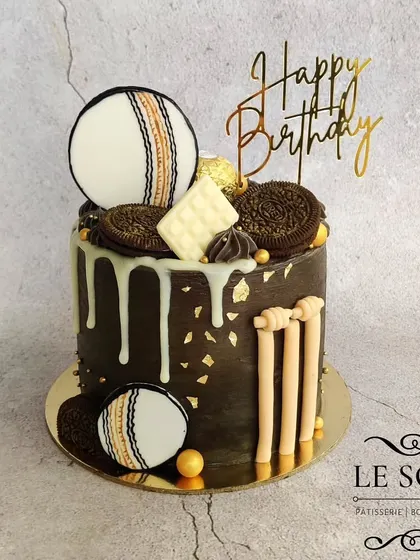 This cricket-themed cake has a touch of elegance. The 1 kg Chocolate Truffle cake is finished with a dark chocolate ganache, a white chocolate drip, and decorated with edible cricket-themed elements.